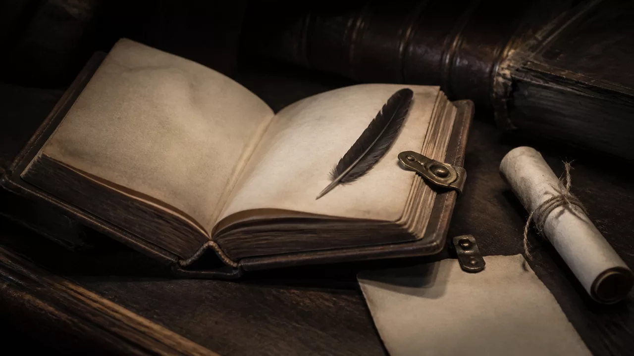 An open leather journal with a feather quill and rolled parchment