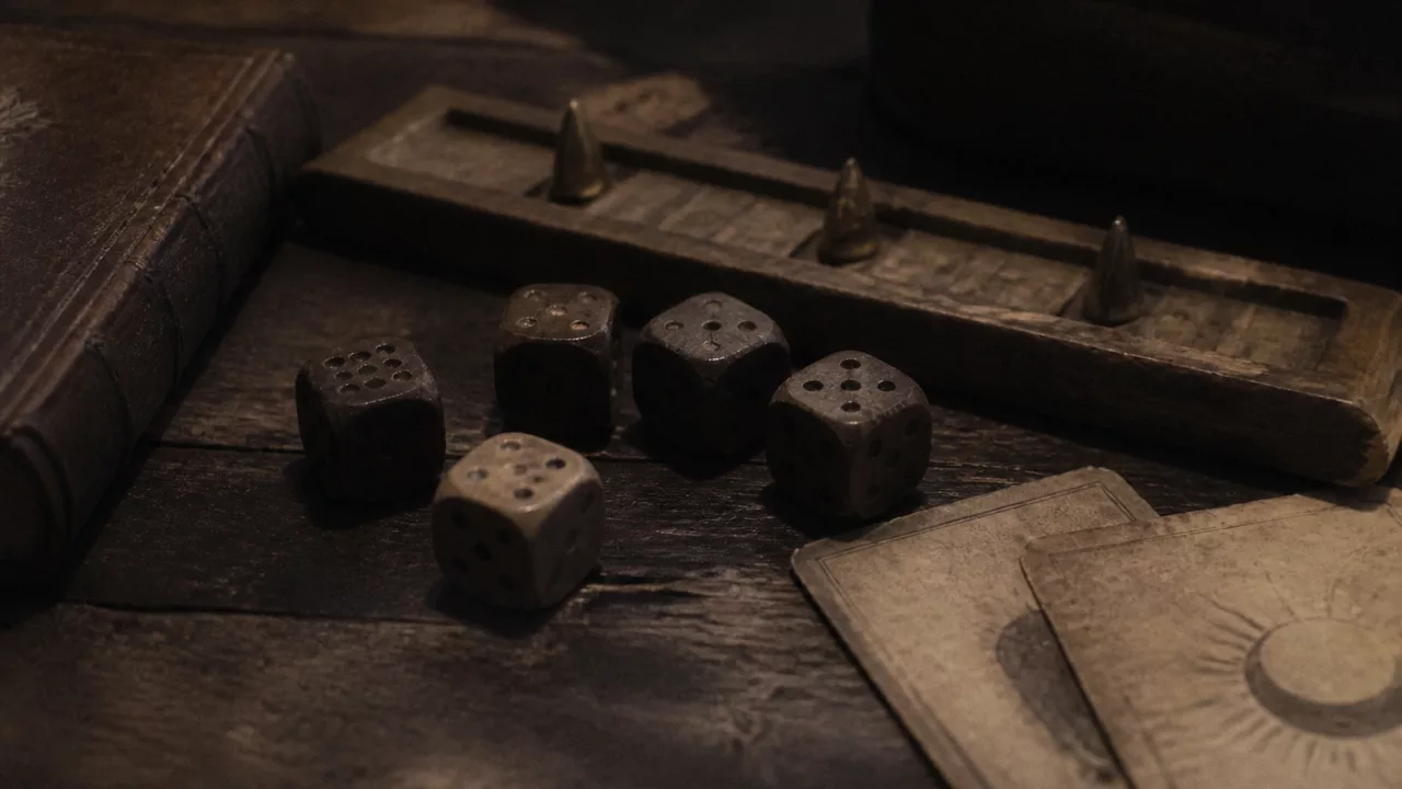 Worn dice, oracle cards, and a wooden progress tracker on an old desk